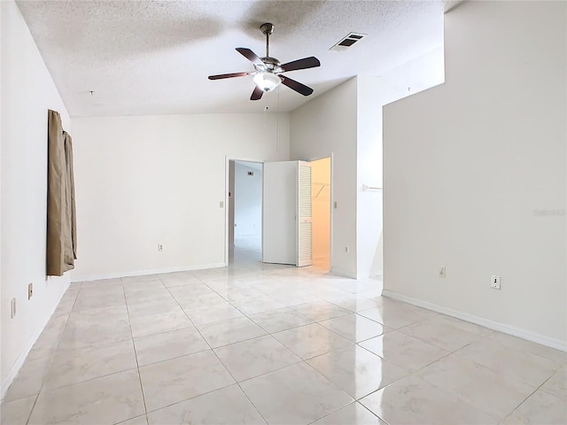 empty room featuring ceiling fan, a textured ceiling, and high vaulted ceiling