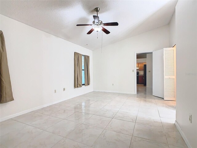 spare room with ceiling fan, lofted ceiling, and a textured ceiling