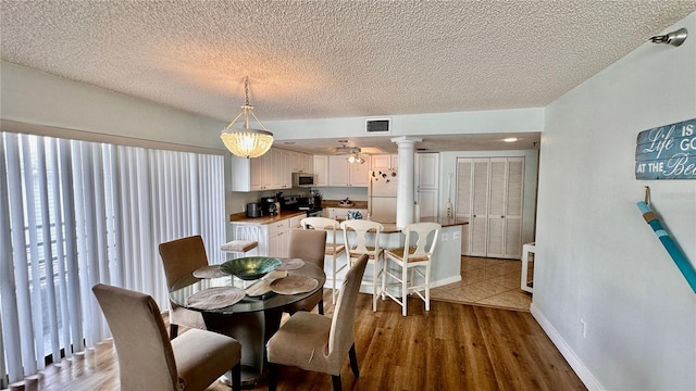 dining room featuring hardwood / wood-style floors, a textured ceiling, and ceiling fan