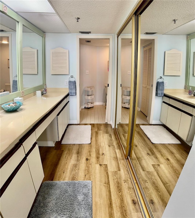 bathroom with vanity, hardwood / wood-style flooring, and toilet