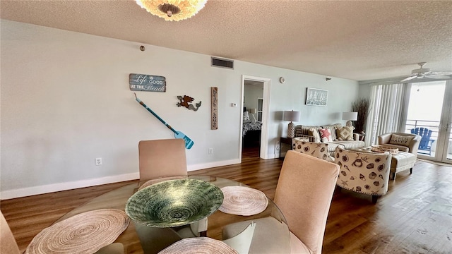 dining area featuring ceiling fan, dark hardwood / wood-style flooring, and a textured ceiling