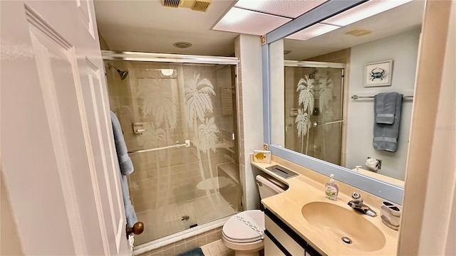 bathroom featuring tile patterned flooring, vanity, an enclosed shower, and toilet