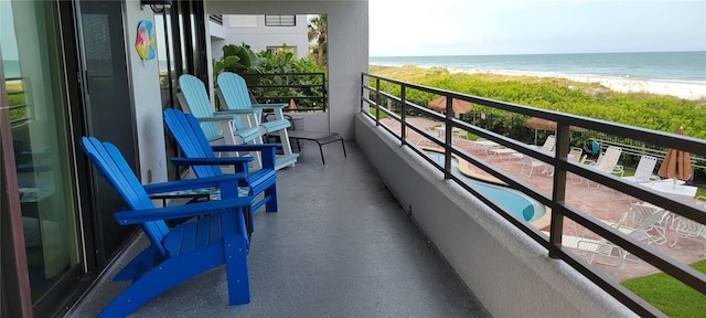 balcony featuring a water view and a beach view