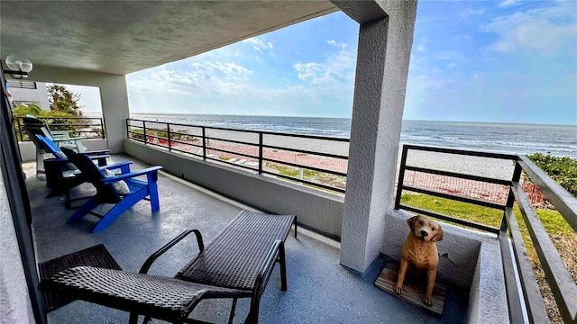 balcony featuring a water view and a beach view