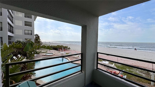 balcony featuring a beach view and a water view