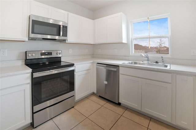 kitchen with white cabinetry, appliances with stainless steel finishes, sink, and light tile patterned floors