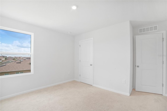 unfurnished room with light colored carpet