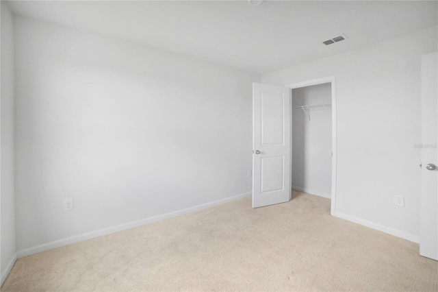 unfurnished bedroom featuring light colored carpet and a closet