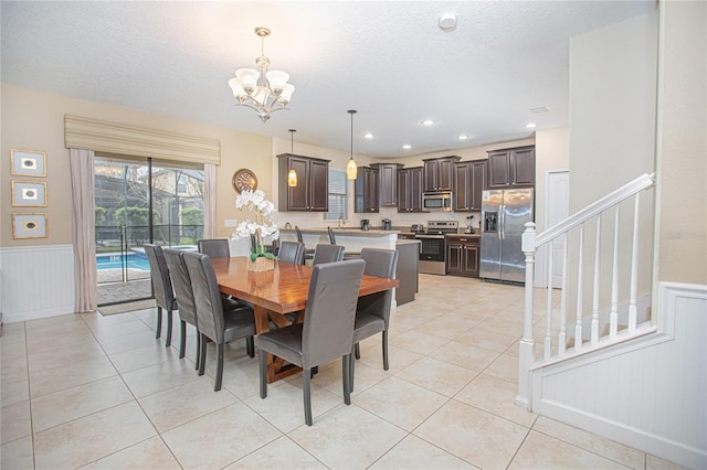 tiled dining space with a chandelier and a textured ceiling