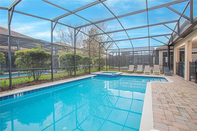 view of pool with a patio area, a lanai, and an in ground hot tub