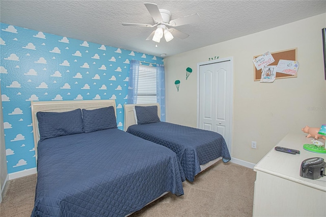 bedroom featuring ceiling fan, a closet, carpet floors, and a textured ceiling