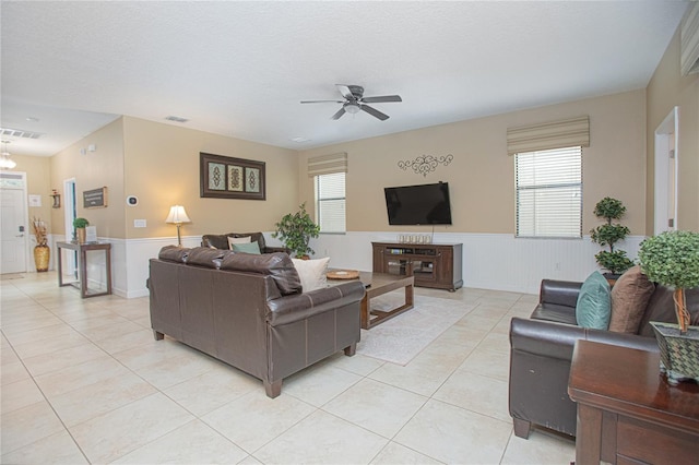 tiled living room featuring a textured ceiling and ceiling fan