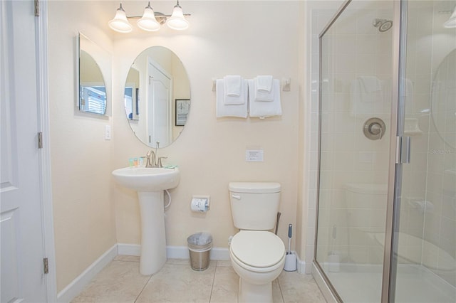 bathroom with toilet, tile patterned floors, walk in shower, and sink