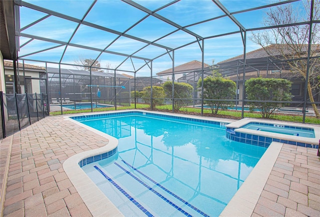 view of pool with an in ground hot tub, a patio, and a lanai