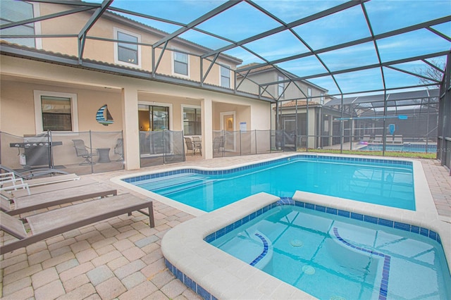 view of swimming pool with a lanai, a patio area, and an in ground hot tub