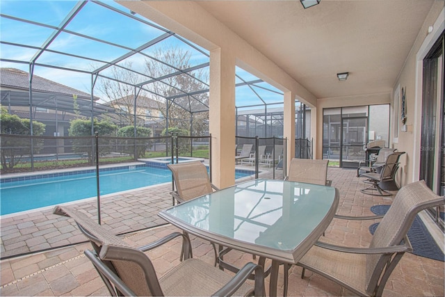 view of pool with glass enclosure and a patio area