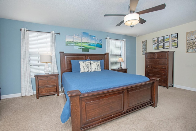 bedroom featuring multiple windows, ceiling fan, and a textured ceiling