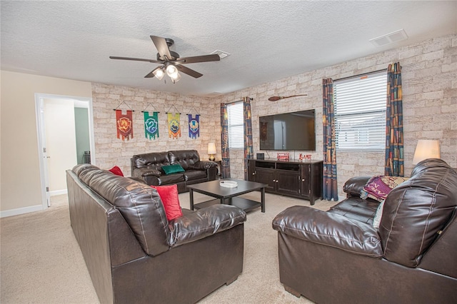 living room featuring light colored carpet, a textured ceiling, and a wealth of natural light