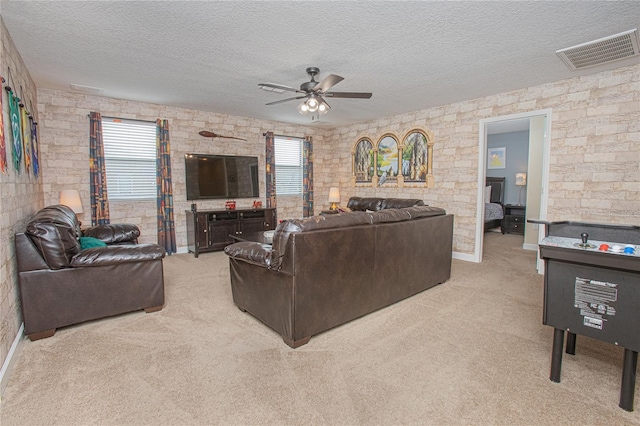 living room with ceiling fan, a textured ceiling, and light carpet