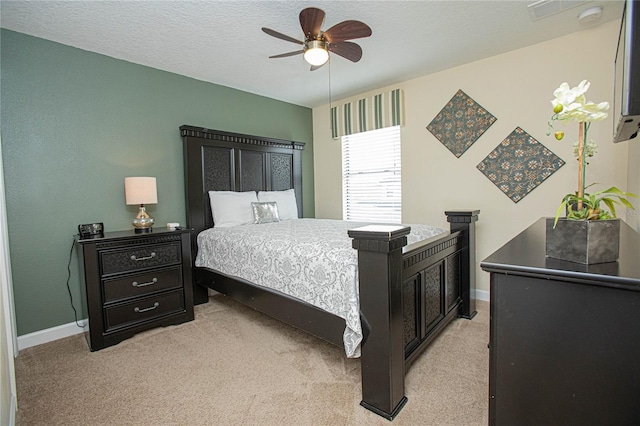 carpeted bedroom with ceiling fan and a textured ceiling