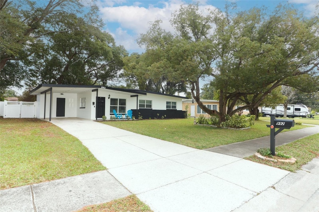 ranch-style house featuring a front yard and a carport