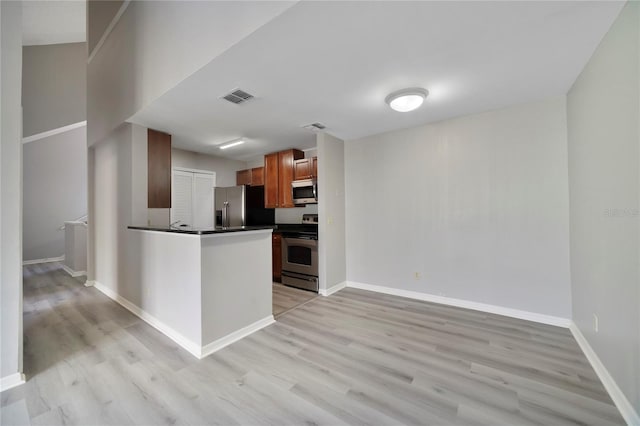 kitchen featuring kitchen peninsula, light wood-type flooring, and stainless steel appliances