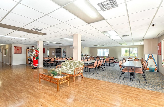 dining room with a drop ceiling and hardwood / wood-style flooring