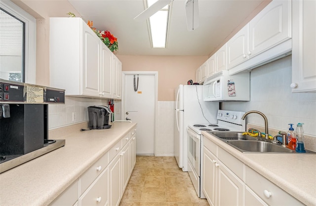 kitchen featuring white cabinets, range with electric stovetop, and sink