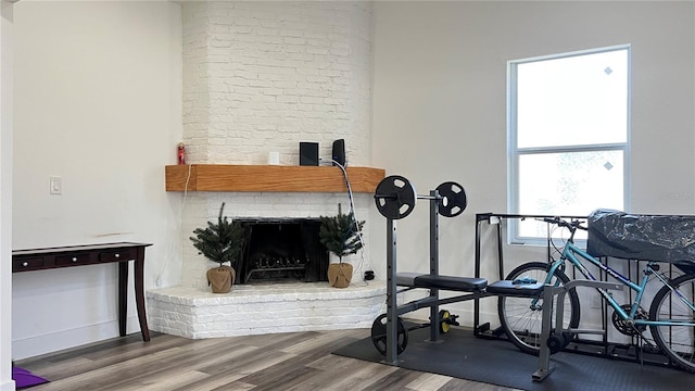 workout room featuring a fireplace and hardwood / wood-style flooring