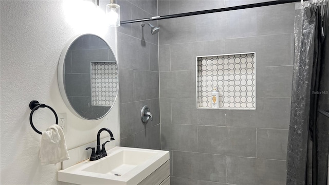 bathroom with vanity and a tile shower