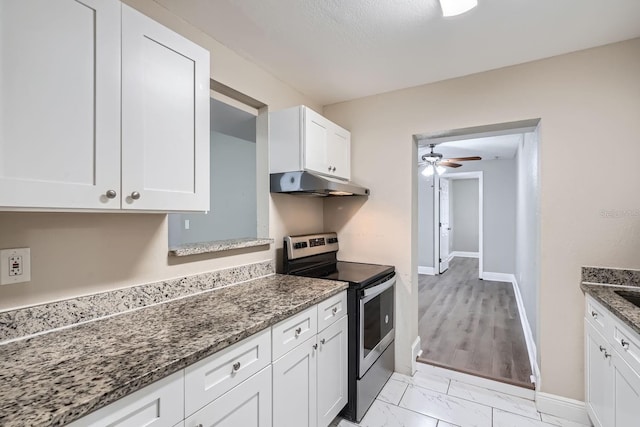 kitchen featuring white cabinetry, ceiling fan, dark stone counters, and stainless steel electric range