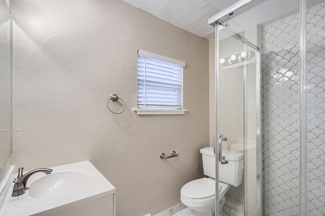 bathroom with vanity, a shower with shower door, and toilet