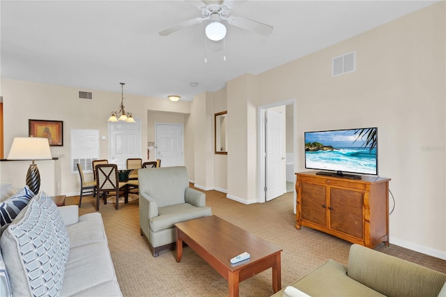 living room featuring ceiling fan with notable chandelier and light carpet