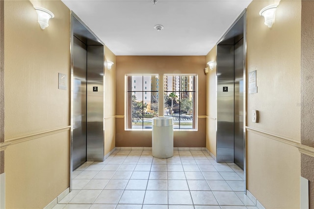 corridor with light tile patterned floors and elevator