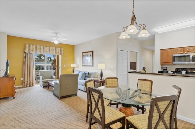 dining room with light carpet and ceiling fan with notable chandelier