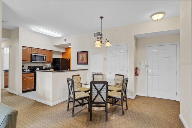 carpeted dining room with a chandelier