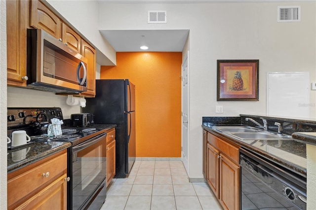 kitchen featuring light tile patterned flooring, sink, dark stone counters, and black appliances