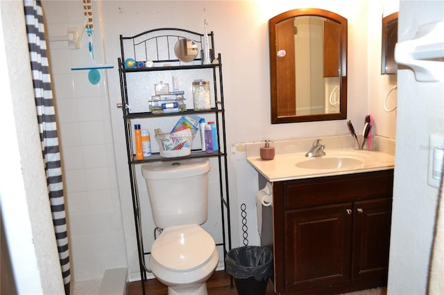 bathroom with curtained shower, vanity, and toilet