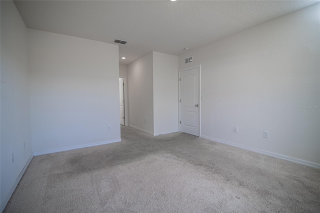 carpeted empty room with a textured ceiling