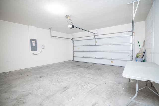 garage featuring electric panel, concrete block wall, and a garage door opener