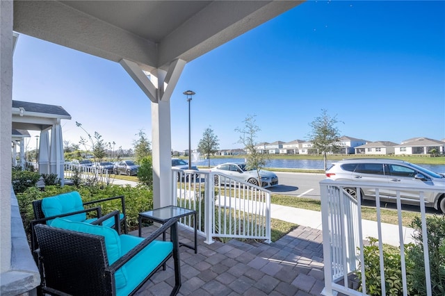 view of patio with an outdoor living space and a water view