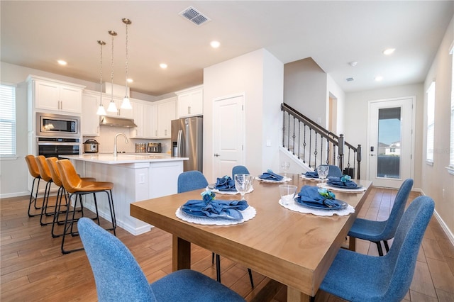 dining room with light hardwood / wood-style floors and sink