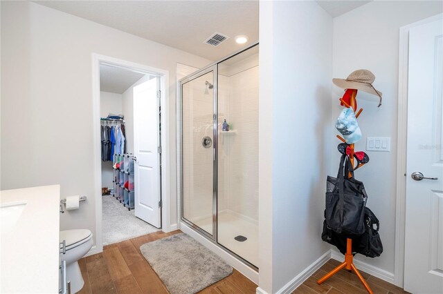 bathroom featuring toilet and a shower with door