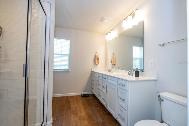 bathroom with toilet, hardwood / wood-style floors, vanity, and walk in shower