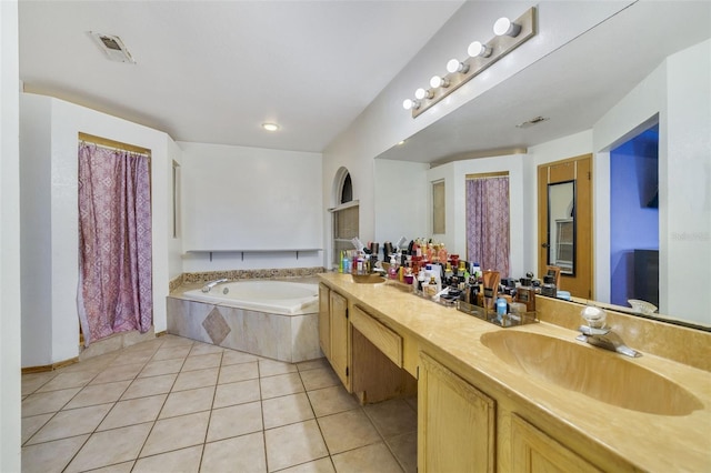 bathroom with tile patterned floors, tiled tub, and vanity