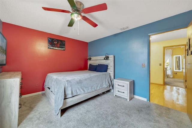 carpeted bedroom featuring a textured ceiling and ceiling fan