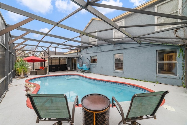 view of swimming pool with glass enclosure and a patio area