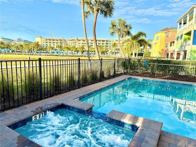 view of swimming pool with a hot tub