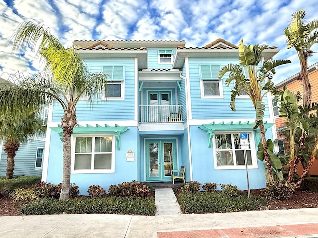 mediterranean / spanish-style house with a balcony and french doors