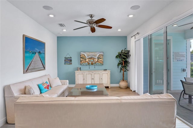 living room featuring ceiling fan and light hardwood / wood-style flooring